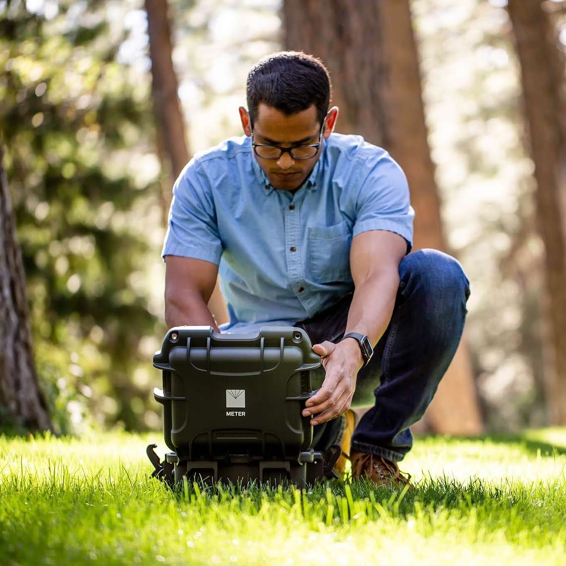 Picture of a researcher with the SATURO infiltrometer which measures field saturated hydraulic conductivity